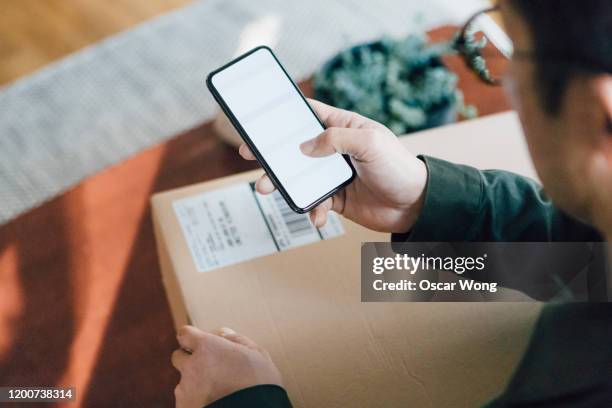 close up shot of man shopping online with mobile phone at home - ホームショッピング ストックフォトと画像