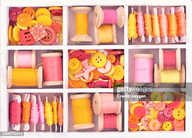 box with sewing set collection of yellow, red, pink spools threads arranged in a white wooden box - button craft foto e immagini stock