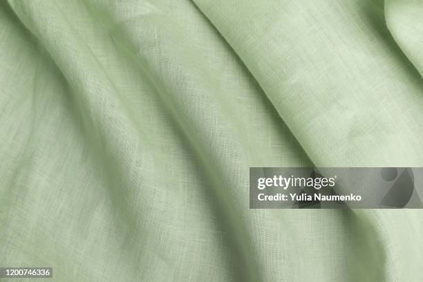 textile made of cannabis and green leaves. fabric as background, fabric with wavy folds. - linnen stockfoto's en -beelden