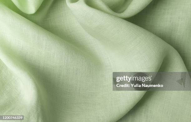 textile made of cannabis and green leaves. fabric as background, fabric with wavy folds. - cannabis sativa stockfoto's en -beelden