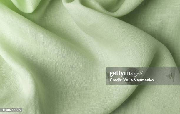 textile made of cannabis and green leaves. fabric as background, fabric with wavy folds. - hemp stock pictures, royalty-free photos & images