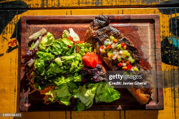 comida típica argentina: bife de chorizo con salsa criolla y ensalada de lechuga, tomate y zanahoria - zanahoria stock pictures, royalty-free photos & images