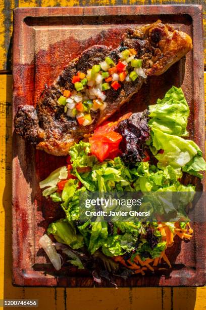 comida típica argentina: bife de chorizo con salsa criolla y ensalada de lechuga, tomate y zanahoria - zanahoria stock pictures, royalty-free photos & images