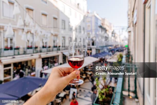 man drinking port wine on a street in lisbon, personal perspective view, lisbon, portugal - activity at port of tanjung priok in jakarta stockfoto's en -beelden