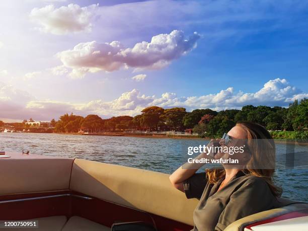 woman on a boat holding a mobile phone, - brasília stock pictures, royalty-free photos & images
