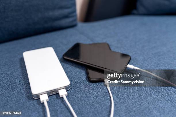 close-up of smart device connected to portable charger - powerbank fotografías e imágenes de stock