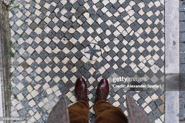 man looking down at azulejo pavement in lisbon, portugal - mens footwear stock pictures, royalty-free photos & images