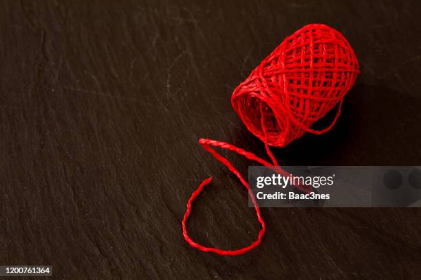 red thread on a rock table - ribbon sewing item stock pictures, royalty-free photos & images