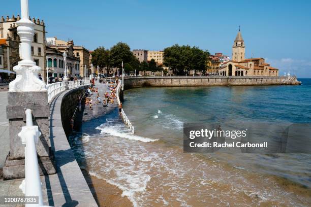 view of the beach and sant peter church from promenade. - asturias stock pictures, royalty-free photos & images