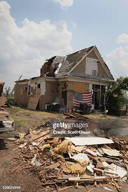 Debris from the May 22 tornado is piled outside a heavily damaged home July 29, 2011 in Joplin, Missouri. The city continues with its recovery...