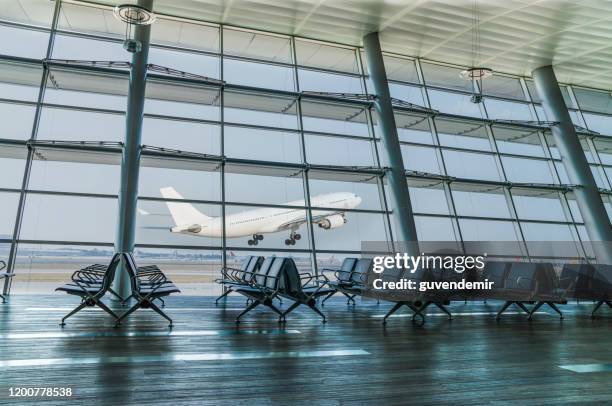 lege luchthaven vertreklounge en vliegtuig opstijgen - airport lounge luxury stockfoto's en -beelden