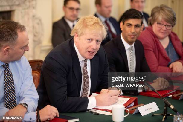 British Prime Minister Boris Johnson speaks during his first Cabinet meeting flanked by his new Chancellor of the Exchequer Rishi Sunak, centre...
