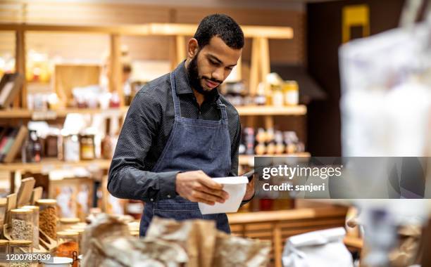 empleado que trabaja en la tienda de bio comestibles - food company manager fotografías e imágenes de stock