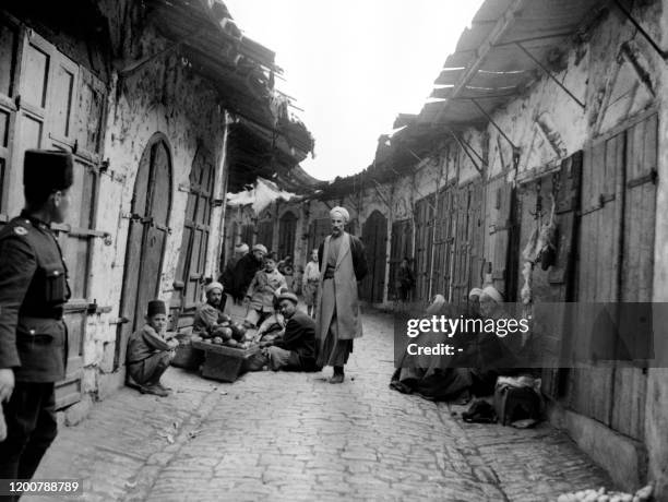 Picture released 27 October 1938 during the British Mandate in Palestine shows Palestinian Arabs watched by a policeman in a street of Hebron where...