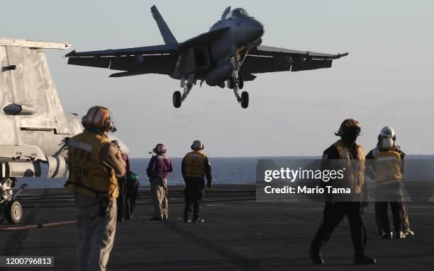 An F/A-18E Super Hornet fighter aircraft descends to land on the flight deck of the USS Nimitz aircraft carrier while at sea on January 18, 2020 off...