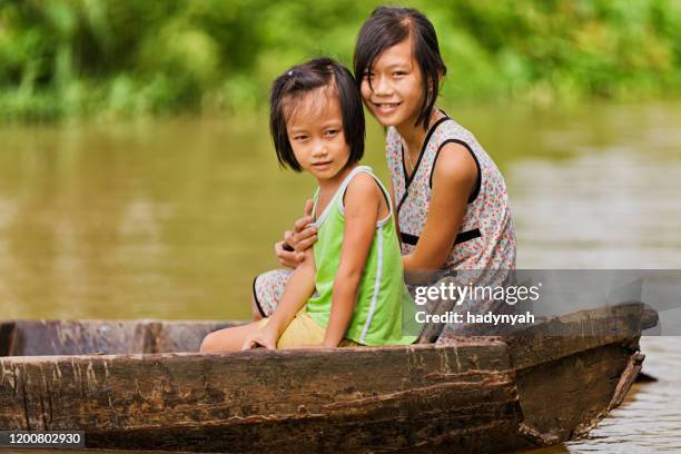 dos chicas vietnamitas en barco en el delta del río mekong, vietnam - vietnam teen fotografías e imágenes de stock