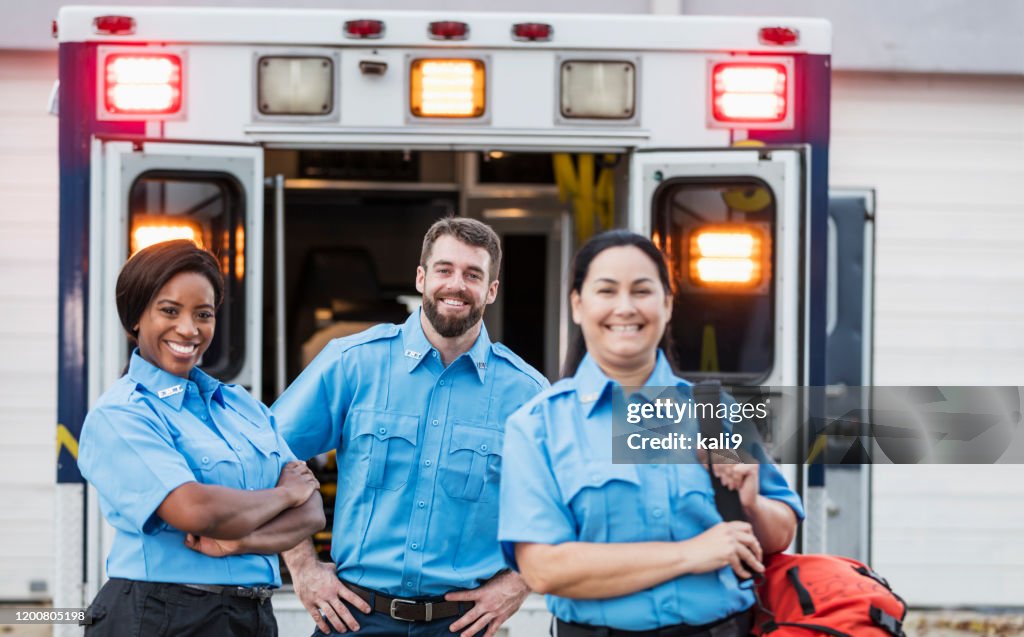 Paramedics standing at the rear doors of an ambulance