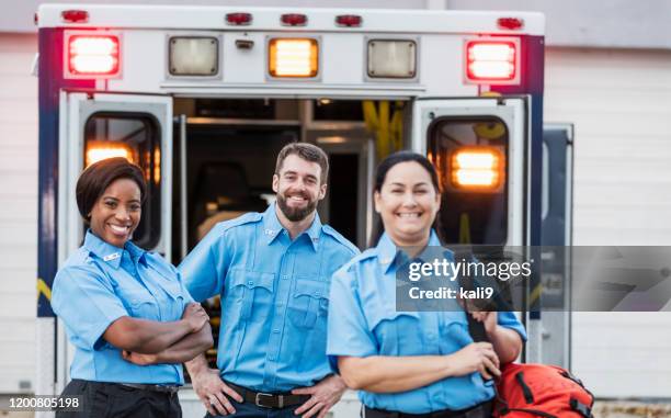 paramedics standing at the rear doors of an ambulance - rescue services occupation stock pictures, royalty-free photos & images