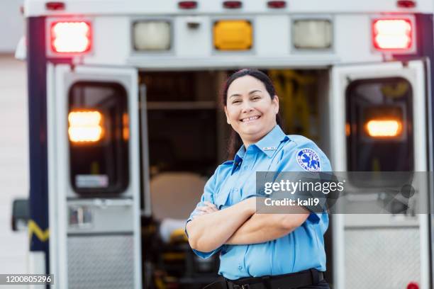 female paramedic standing at the rear doors of an ambulance - ambulance doors open stock pictures, royalty-free photos & images