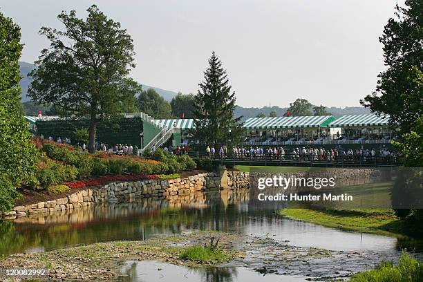 Spectators cross the bridge on the 18th hole during the second round of The Greenbrier Classic at The Old White TPC on July 29, 2011 in White Sulphur...