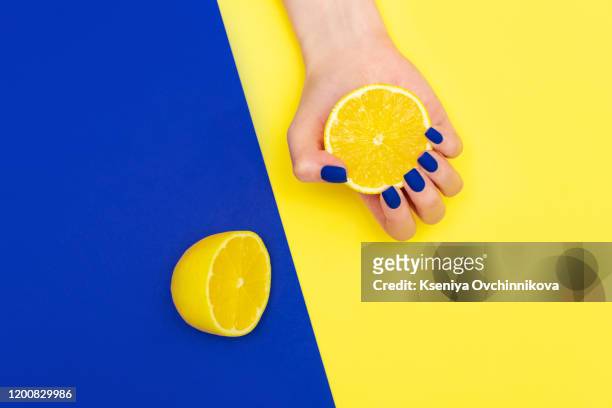 bright blue shiny creative manicure on yellow background. women's hands through a torn sheet of paper - covered food with wine stock pictures, royalty-free photos & images