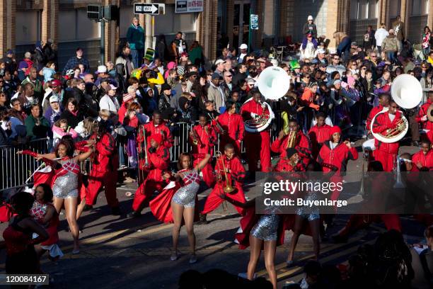 Daytime view of a uniformed brass band and dancers as they perform in the Mardi Gras Parade, Mobile, Alabama, 2010.