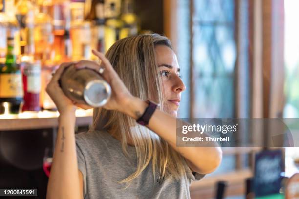 female bartender making cocktails - cocktail shaker stock pictures, royalty-free photos & images