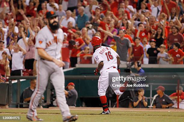 Edgar Renteria of the Cincinnati Reds runs to first base after a single to drive in the game-winning run in the 13th inning against Brian Wilson of...