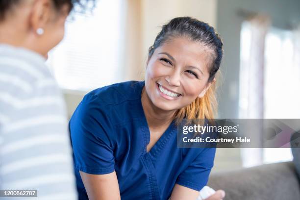 healthcare nurse smiling at patient after exam - nursing scrubs stock pictures, royalty-free photos & images