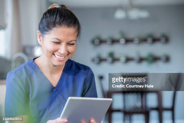 happy nurse or doctor video chatting with patients while working from home - philippines women stock pictures, royalty-free photos & images