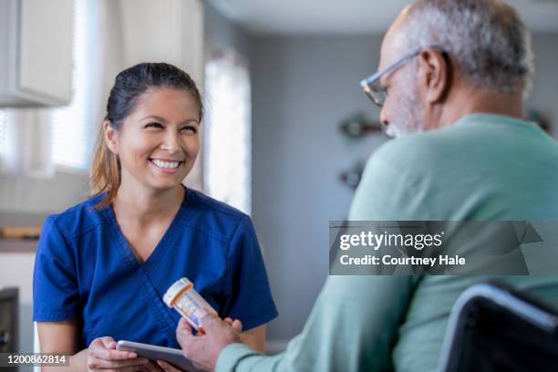 thuiszorg verpleegkundige brengt nieuwe recepten voor senior man - caregiver and senior stockfoto's en -beelden