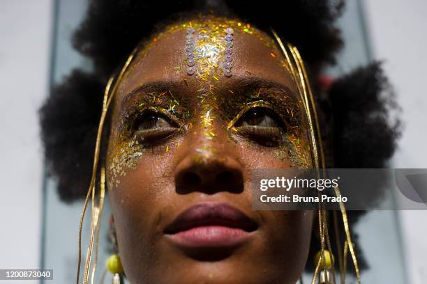 Woman wearing glitter looks on during Ceu na Terra at the Street carnival celebration at Santa Teresa Neighbourhood on February 15, 2020 in Rio de...