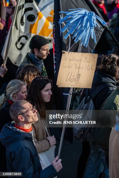Demonstrator carries a mop with a poster reading "The angry mob finds Bjoern Hoecke stupid" during a protest themed "Not with us! No pacts with...