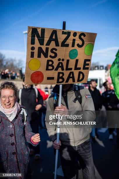 Demonstrator carries a poster reading "Nazis into the ball bath" during a protest themed "Not with us! No pacts with fascists any time or anywhere!"...
