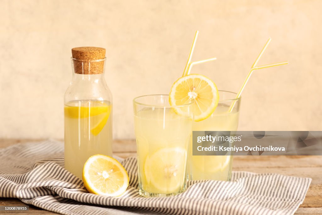 Jar of tasty fresh lemonade with lemons in background