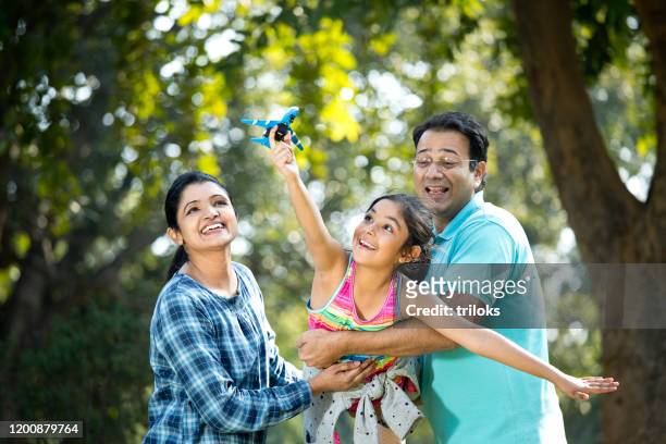 parents with daughter flying toy airplane - parent stock pictures, royalty-free photos & images