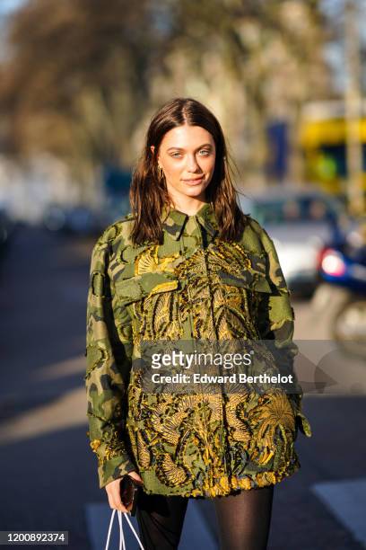 Heloise Agostinelli wears earrings, a khaki print shirt with embroideries, outside Dior, during Paris Fashion Week - Haute Couture Spring/Summer...