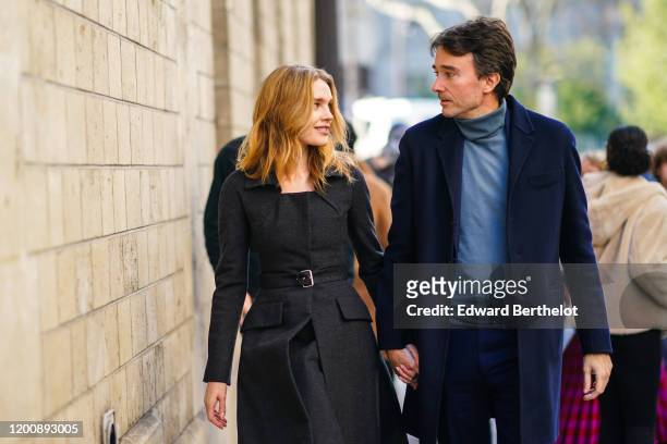 Natalia Vodianova wears a black dress and a belt ; Antoine Arnault wears a blue turtleneck pullover and a blue long coat, outside Dior, during Paris...