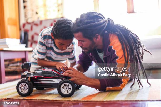 father and son playing with remote control car - remote control car stock pictures, royalty-free photos & images
