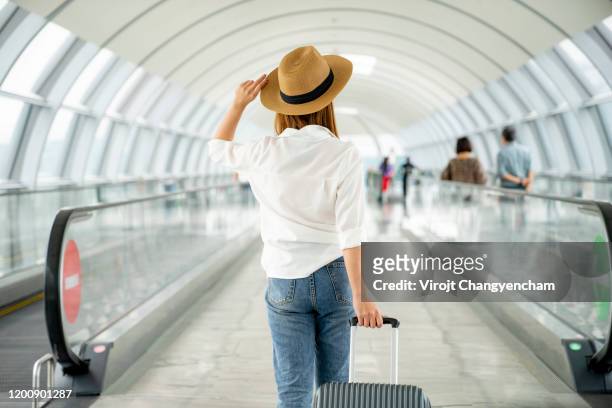 young casual female traveler with suitcase at airport - journey fotografías e imágenes de stock