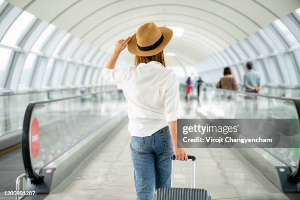 young casual female traveler with suitcase at airport - woman travel fotografías e imágenes de stock