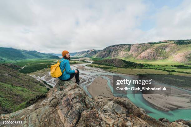 mujer sentada en el fondo del río en la patagonia - patagonia fotografías e imágenes de stock