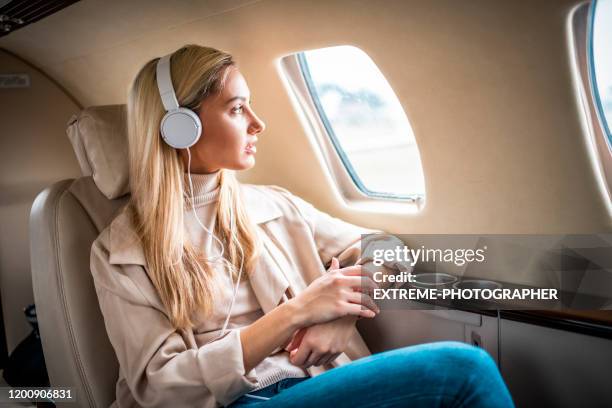 ung affärskvinna reser med ett privatflygplan - woman airplane headphones bildbanksfoton och bilder