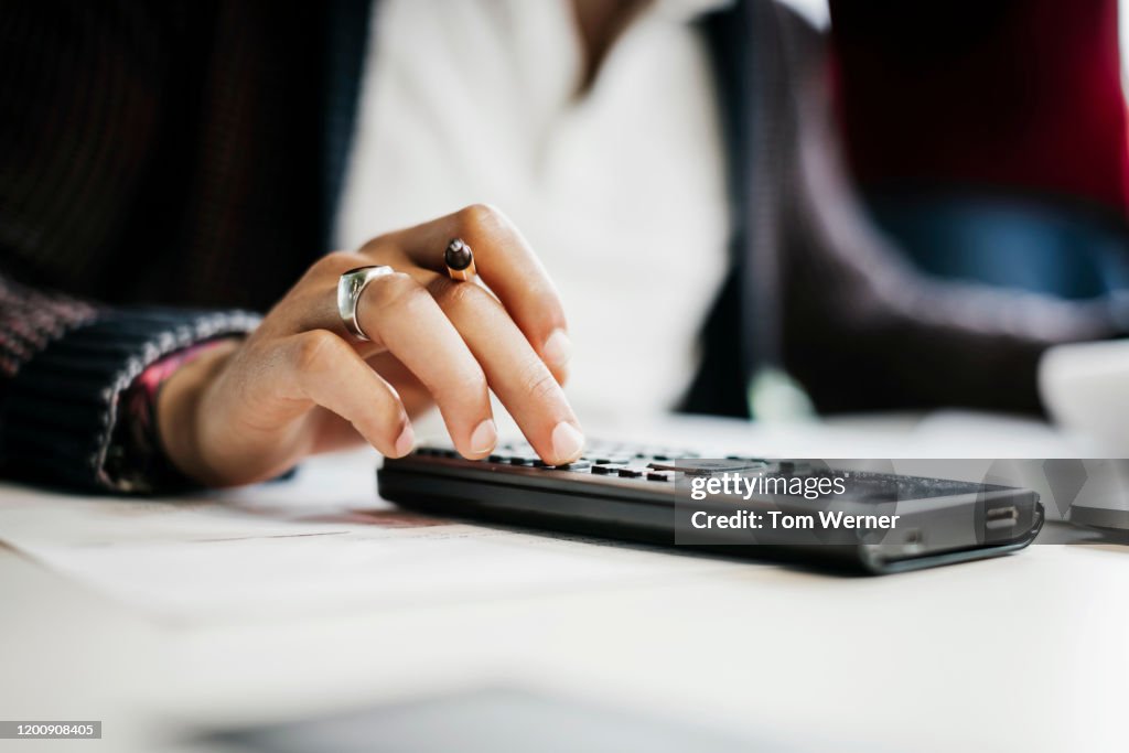 Close Up Of Student Using Calculator In Public Library