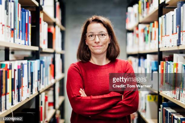 portrait of librarian with arms crossed - librarian stock pictures, royalty-free photos & images