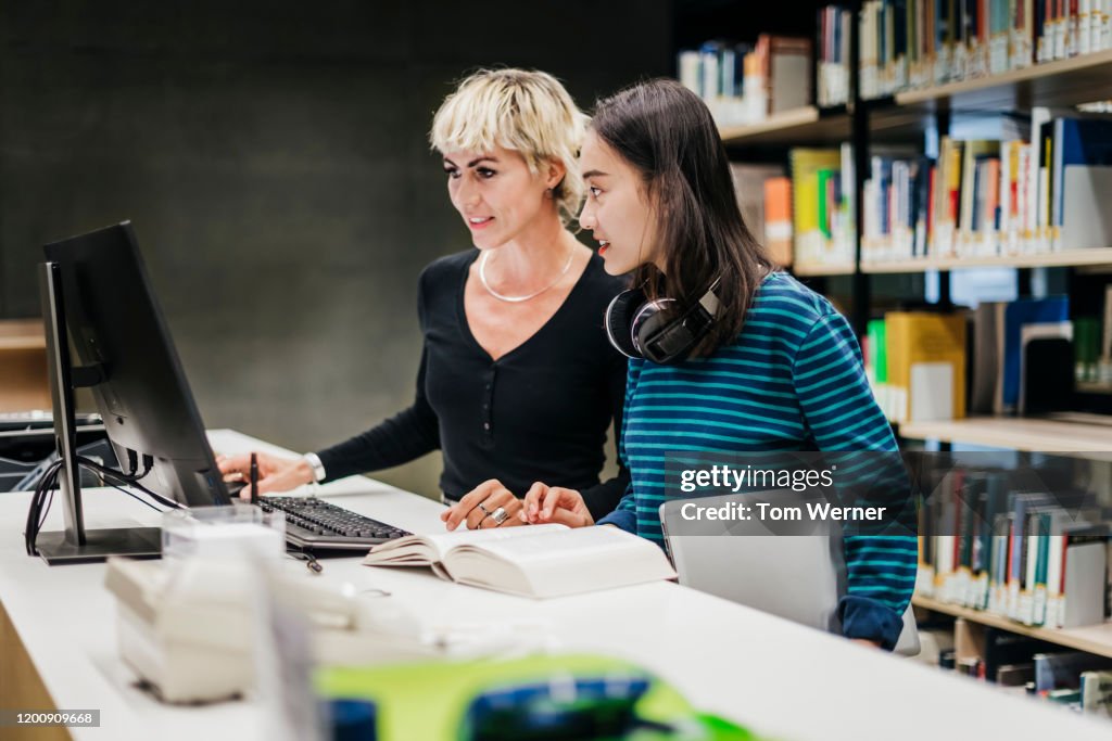 Two Friends Using A Computer Two Friends Using Library Computer Together High-Res Stock Photo ...