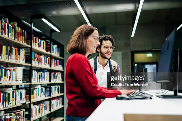 student asking librarian to help locate books using computer - librarian stock pictures, royalty-free photos & images