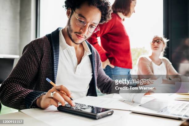 student using calculator to work out math problem - mathematics stock pictures, royalty-free photos & images