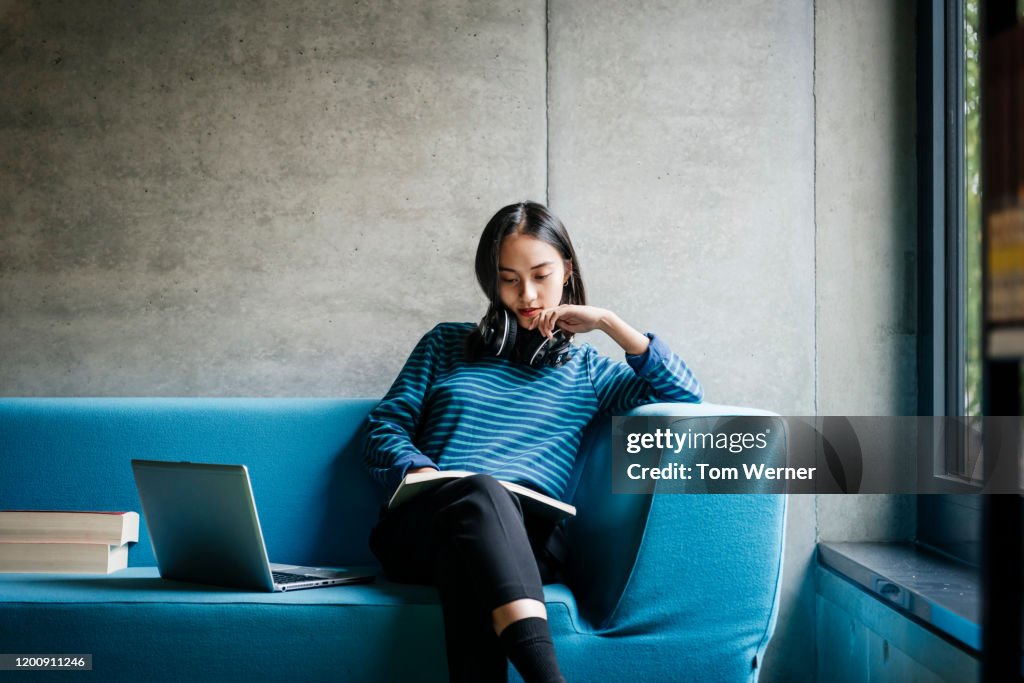 Young Woman Sitting On Couch In Library