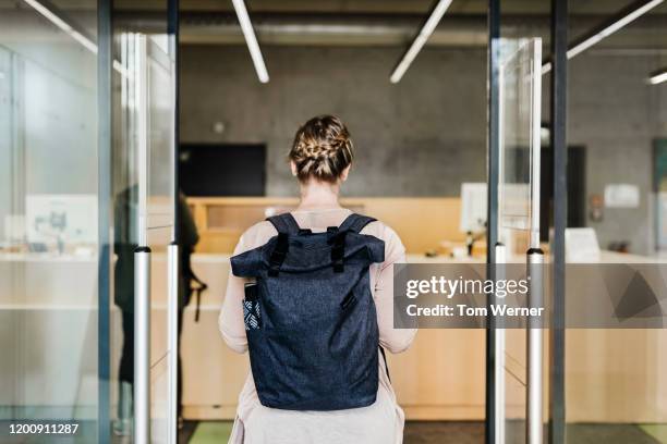 woman walking through library entrance - リュックサック ストックフォトと画像